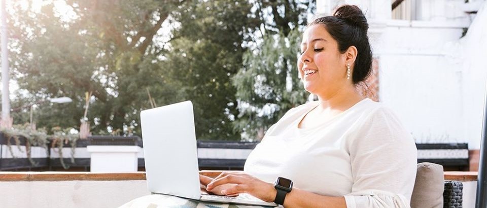 Woman sitting with laptop on lap